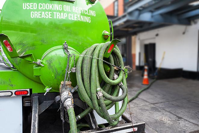 a grease trap being pumped by a sanitation technician in Alamo